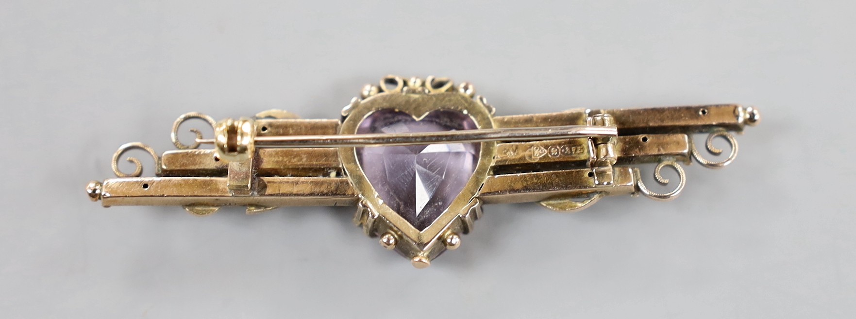 An early 20th century 9ct gold, heart shaped amethyst and seed pearl set bar brooch, 59mm, gross weight 5.7 grams.
